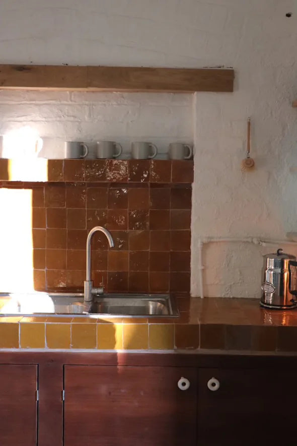 Sunlit rustic kitchen with Sahara sunset zellige tiles in amber and mustard on the backsplash and worktop